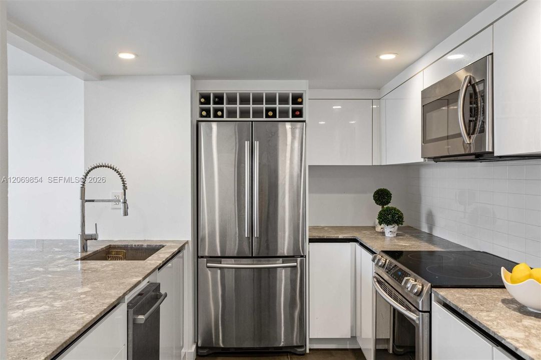 High-end stainless steel appliances, sleek cabinetry, and elegant stone countertops enhance the kitchen’s sophisticated appeal. Thoughtfully designed with a smart layout, it offers a seamless connection to the spacious living area, creating a bright and inviting atmosphere