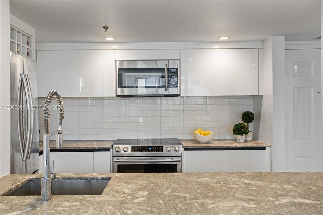 This beautifully designed open-concept kitchen seamlessly blends style and functionality. The extra-large island provides ample prep space and additional storage, making it perfect for both casual meals and entertaining
