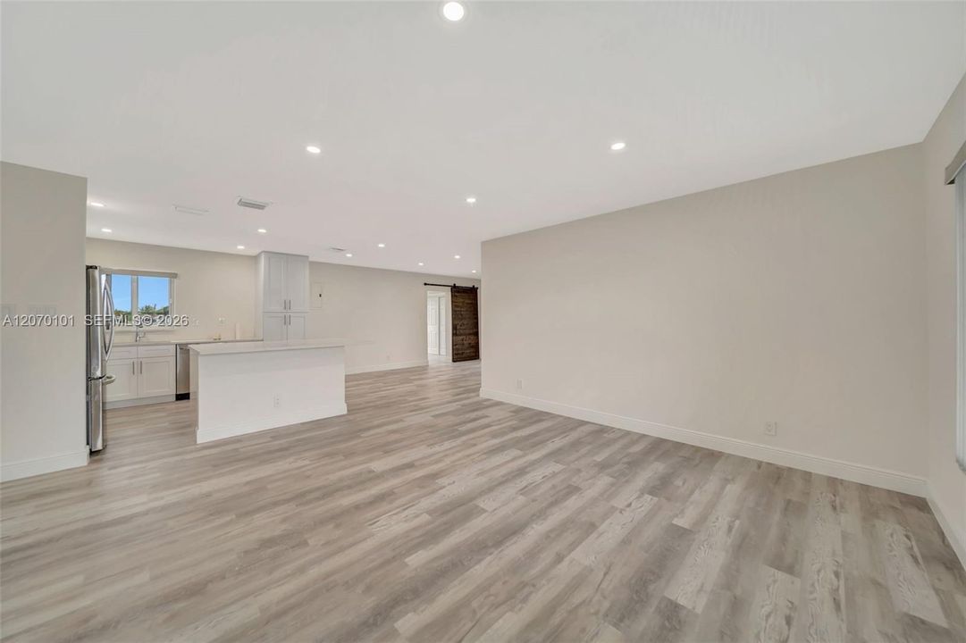 Wide shot toward kitchen, barn door visible