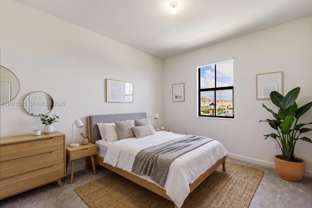 Continue down the hall and you'll find another bright, comfortable bedroom with a large window and plenty of room for a full bedroom setup.