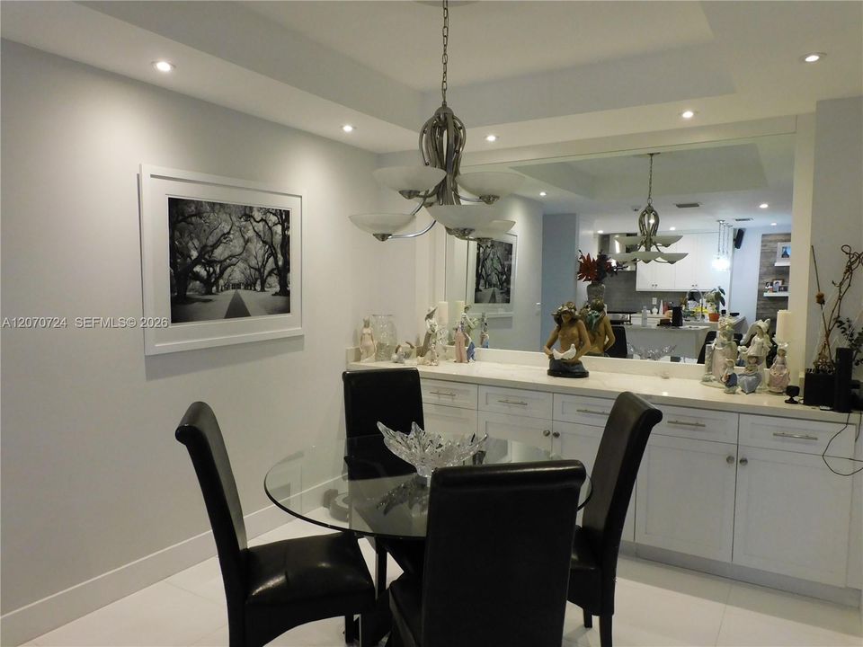 Dining area with custom made buffet side piece with quartz countertop - custom mirror and led lighting at tray ceiling.