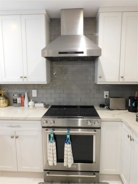 KItchen Aid glass top stove and oven combo. Ceiling height cabinets for extra storage.