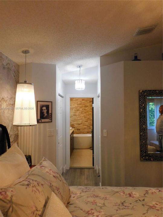 Primary Bedroom view leading to his/hers closets and ensuite.