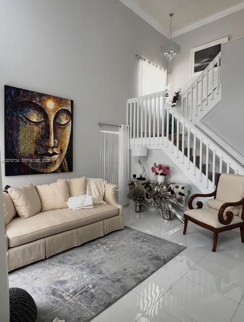 View from entrance to soaring ceiling in foyer and living room area leading to staircase. 24 X24 porcelain tiles through all downstairs.