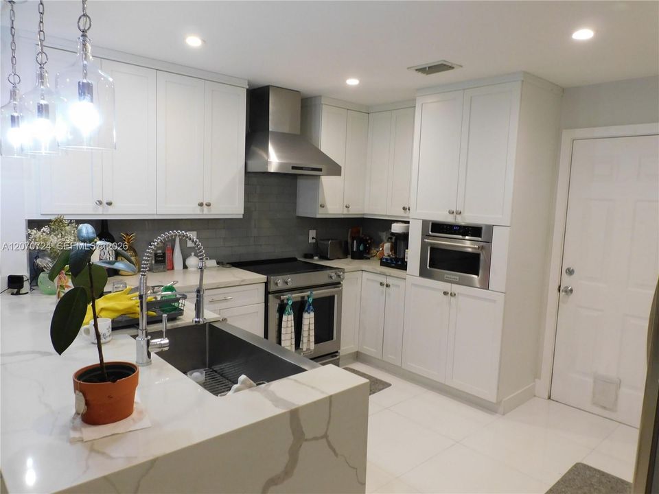 Water fall counter Island. Plenty of counter space - cabinets - lighting - to enjoy cooking to the fullest!