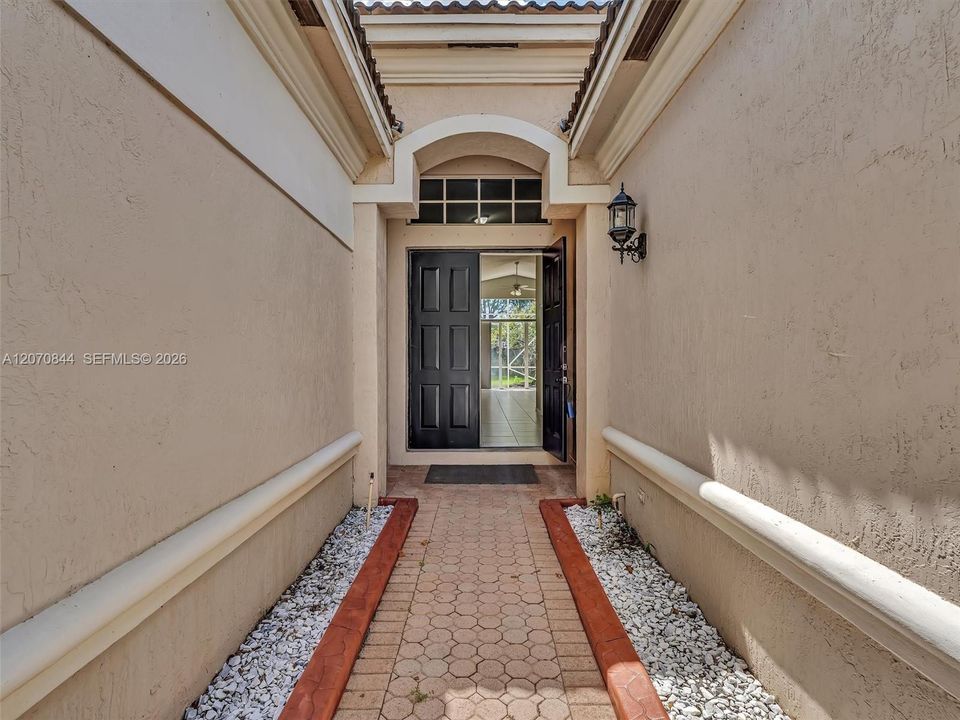 Welcoming double door entryway entrance featuring a charming walkway, decorative landscaping rocks, and space for plants or personalized landscaping touches, creating beautiful curb appeal.