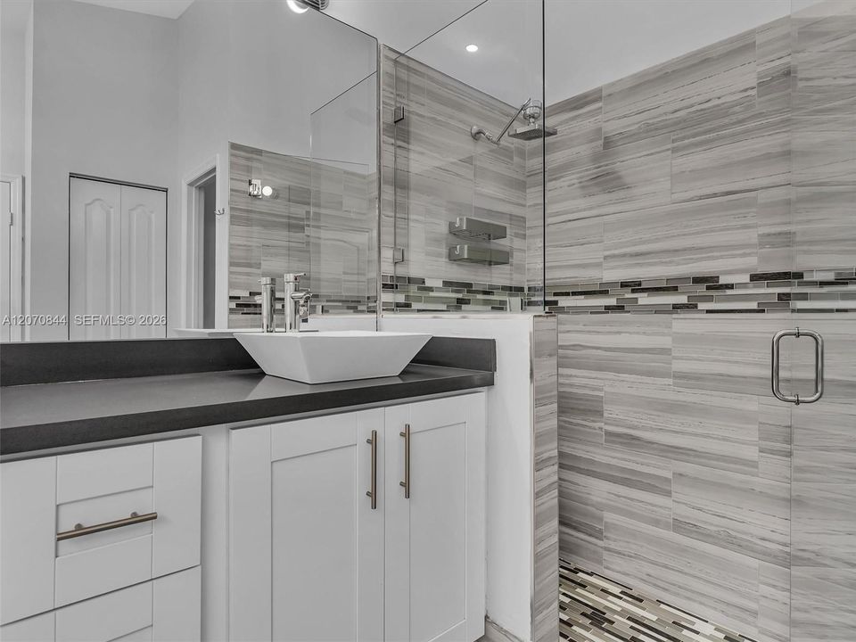 Spacious primary bathroom featuring dual vanities, a large soaking tub, a walk-in shower with glass doors, and a separate private toilet area for added privacy.