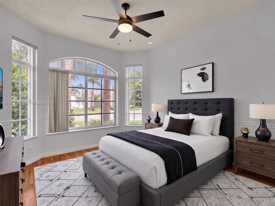 Spacious second bedroom featuring hardwood floors, a charming bay window, and abundant natural light, creating a warm and inviting space.