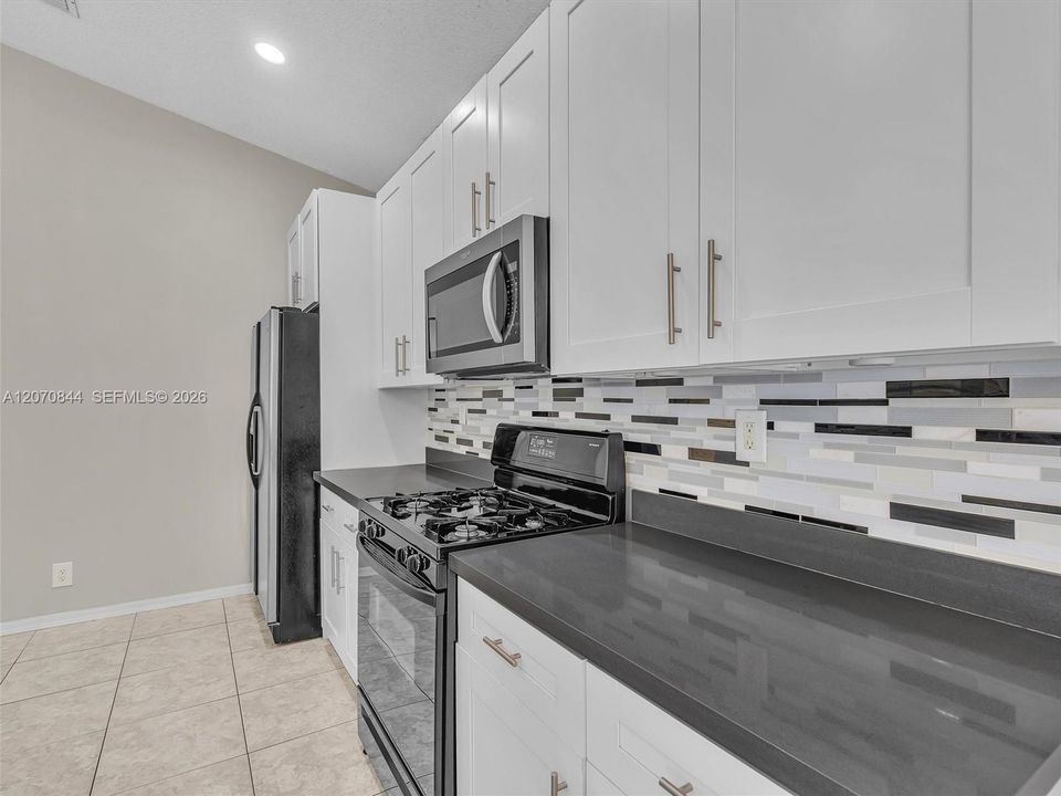 The kitchen layout provides ample workspace meal preparation and features a gas stove for effortless cooking.