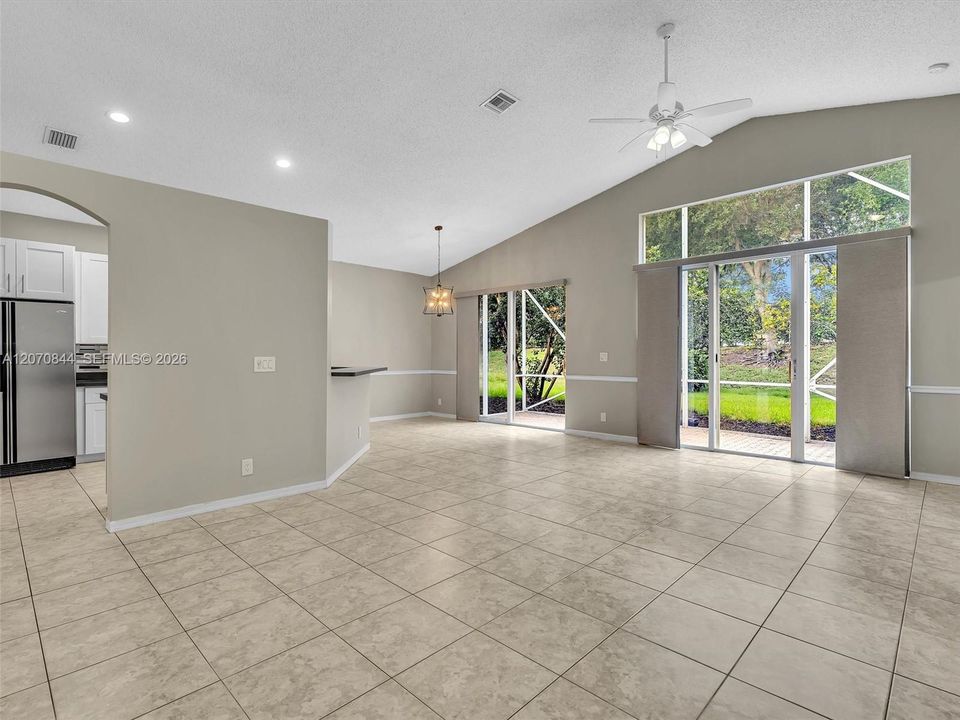 Spacious living room featuring soaring vaulted ceiling, creating an open, airy atmosphere filled with natural light.