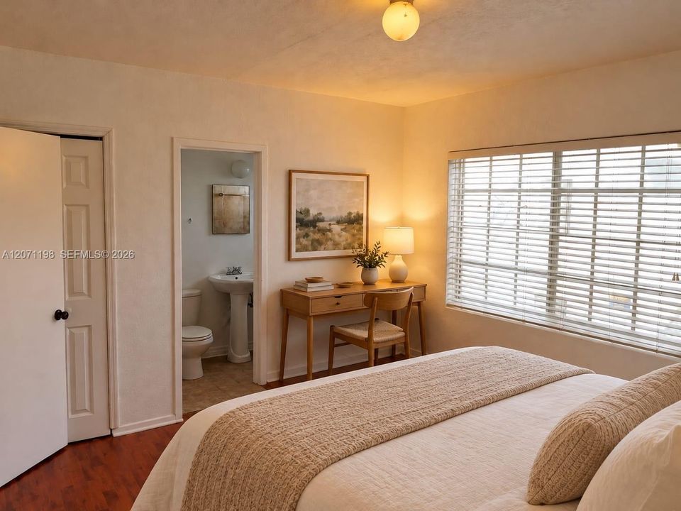 Room featuring wood-finish flooring, a six-panel closet door, and a large multi-pane window with horizontal blinds