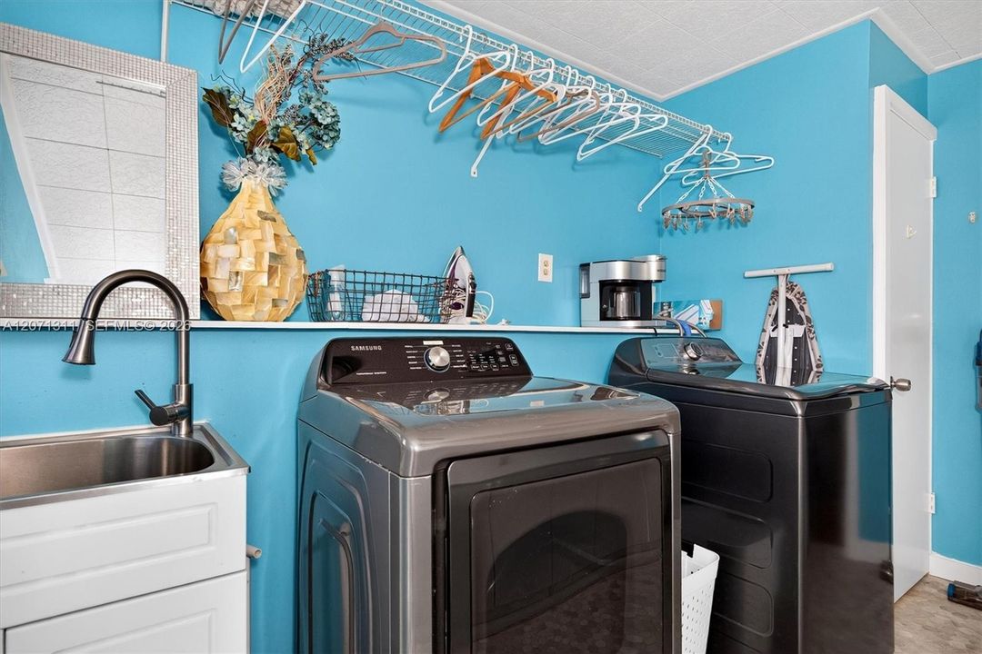 Inside laundry room w/separate wash basin, full size washer/dryer