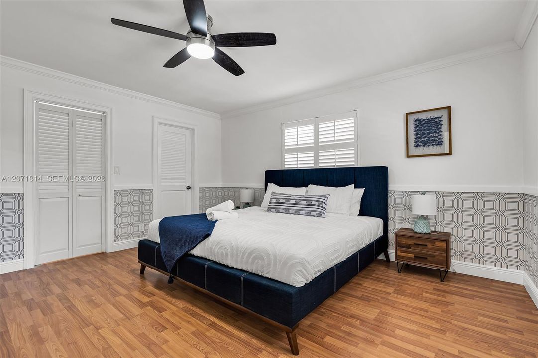 Bright bedroom featuring wood flooring and ceiling fan
