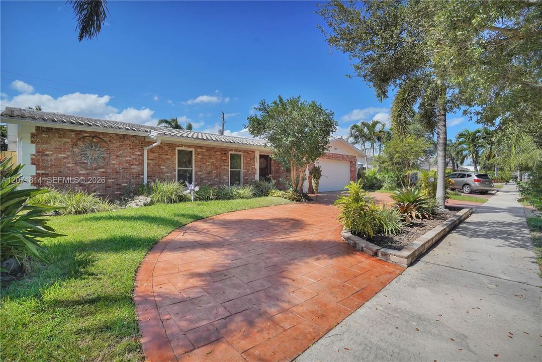 Charming curb appeal with mature landscaping and paved walkway