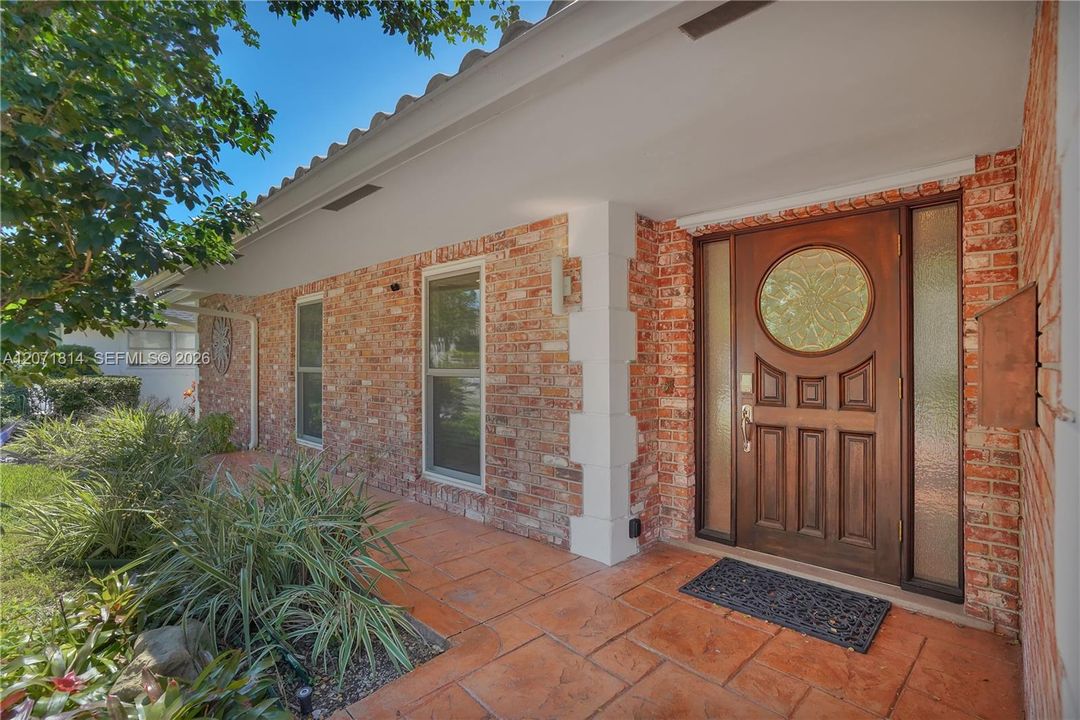 Classic front entrance featuring a decorative wood door and brick accents
