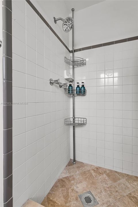 Walk-in shower featuring sleek tile finishes