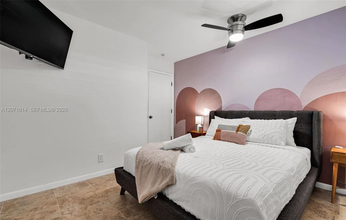Well-appointed bedroom with wall-mounted TV and soft neutral palette