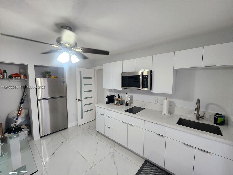 Open, modern living space with sleek rectified tile flooring, quality closets and cabinetry throughout