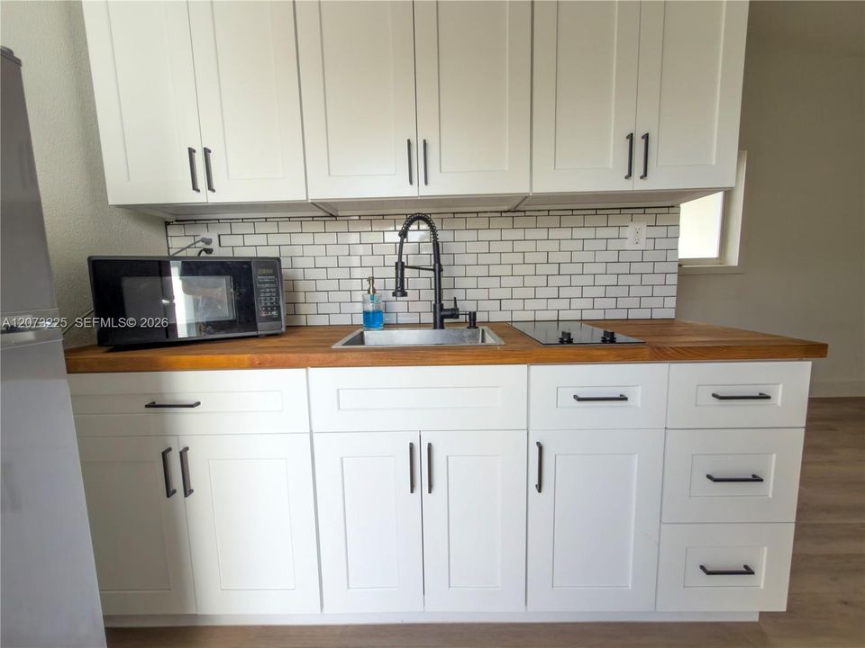 Microwave, sink & two-burner cooktop.