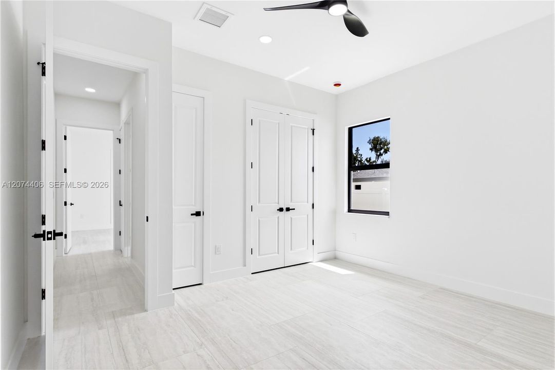 A COMFORTABLE THIRD BEDROOM offers a bright, peaceful retreat for FAMILY or GUESTS w/ modern finishes & generous closet space.