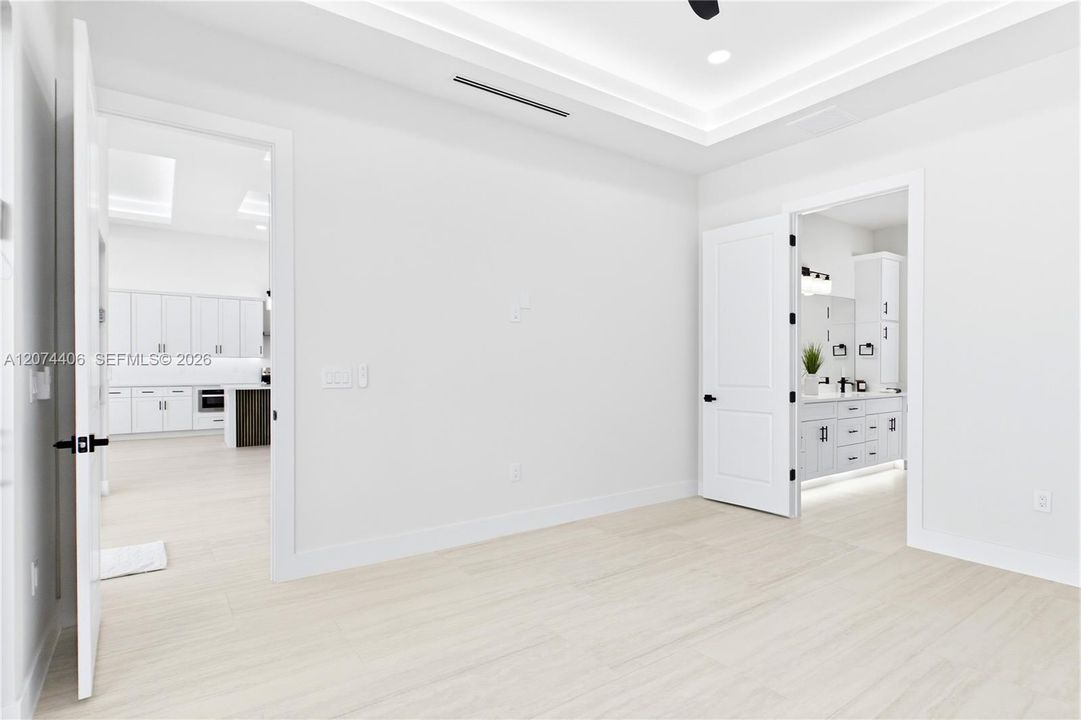 RETREAT to a SERENE PRIMARY SUITE designed for relaxation, w/ a spacious layout, ambient LED-LIT TRAY CEILING & spa-like ensuite.