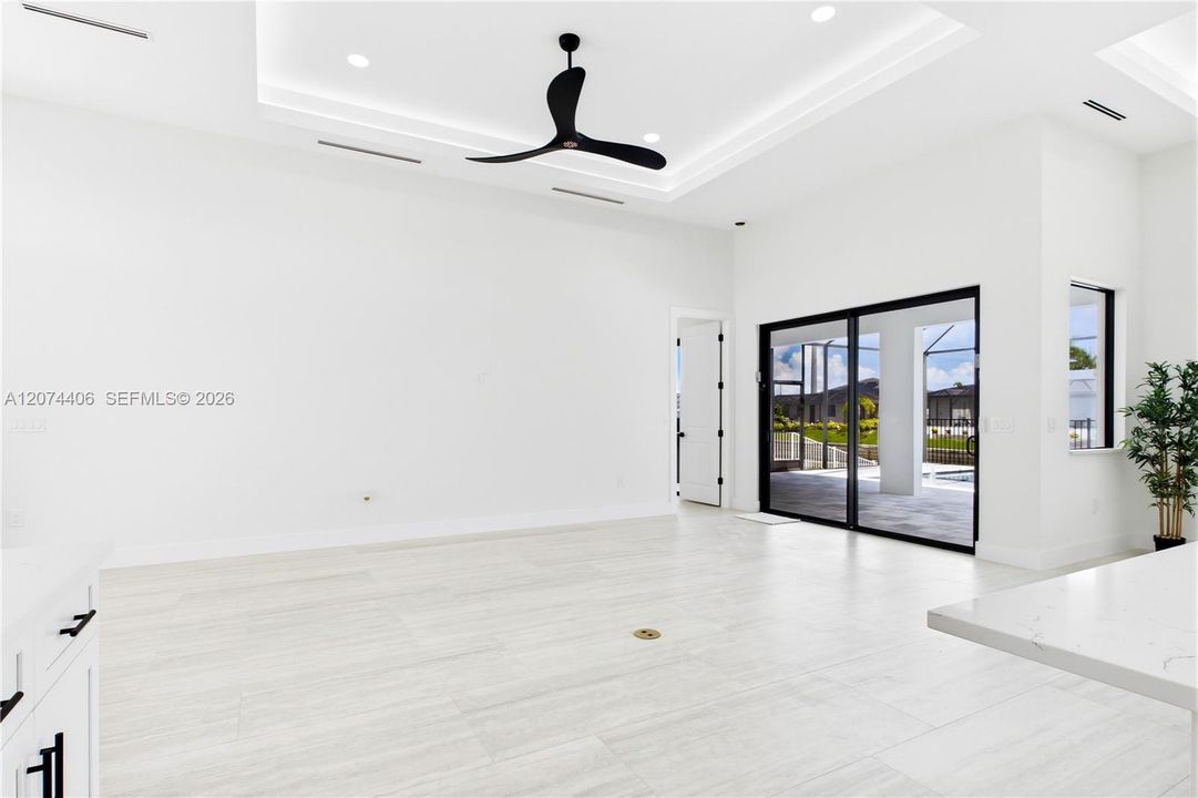 OPEN LIVING AREA showcases a dramatic DOUBLE-TRAY CEILING w/ LED ACCENT LIGHTING, sleek LINEAR A/C DIFFUSERS & contemporary statement ceiling fan.