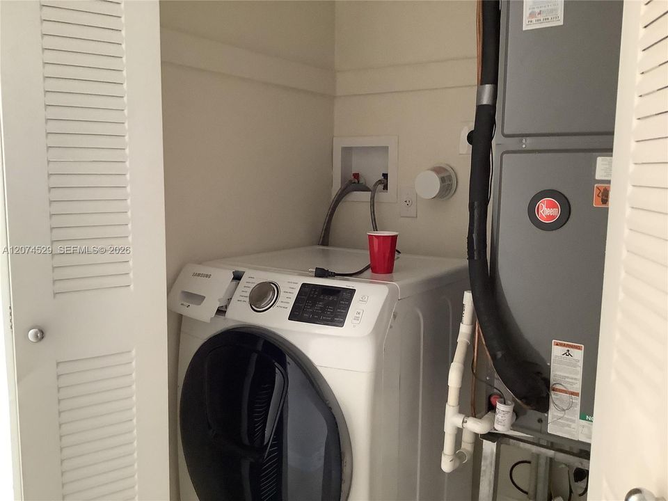 Washer inside the UNIT and Dryer OUTSIDE in a laundry room