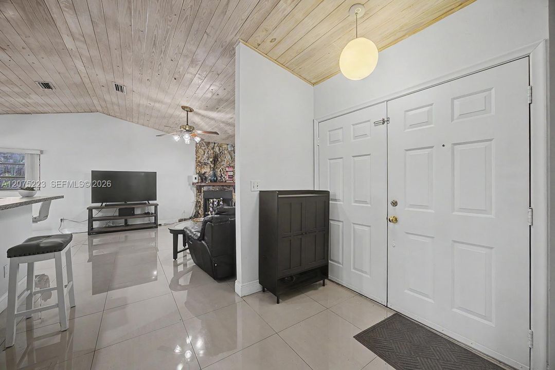 Welcoming entry opens into the home’s bright, open living spaces with vaulted wood-plank ceilings.