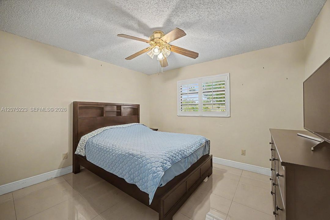 Comfortable secondary bedroom 3 with tile flooring, ceiling fan and natural light.