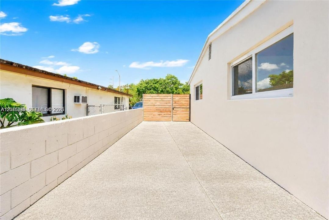 Wide side driveway with secure privacy gate and ample access.