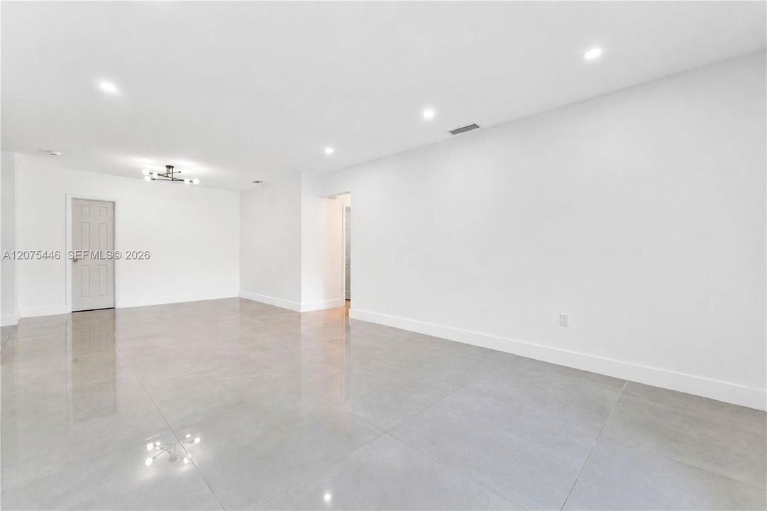 Spacious open-concept living area with recessed lighting.