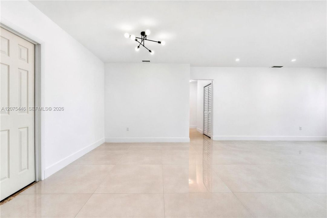 Open-concept living and dining area with modern lighting.
