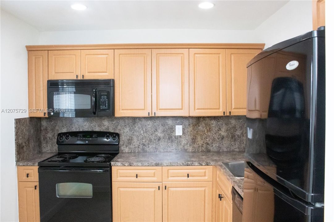Recessed lighting in the kitchen. All Black Appliances.