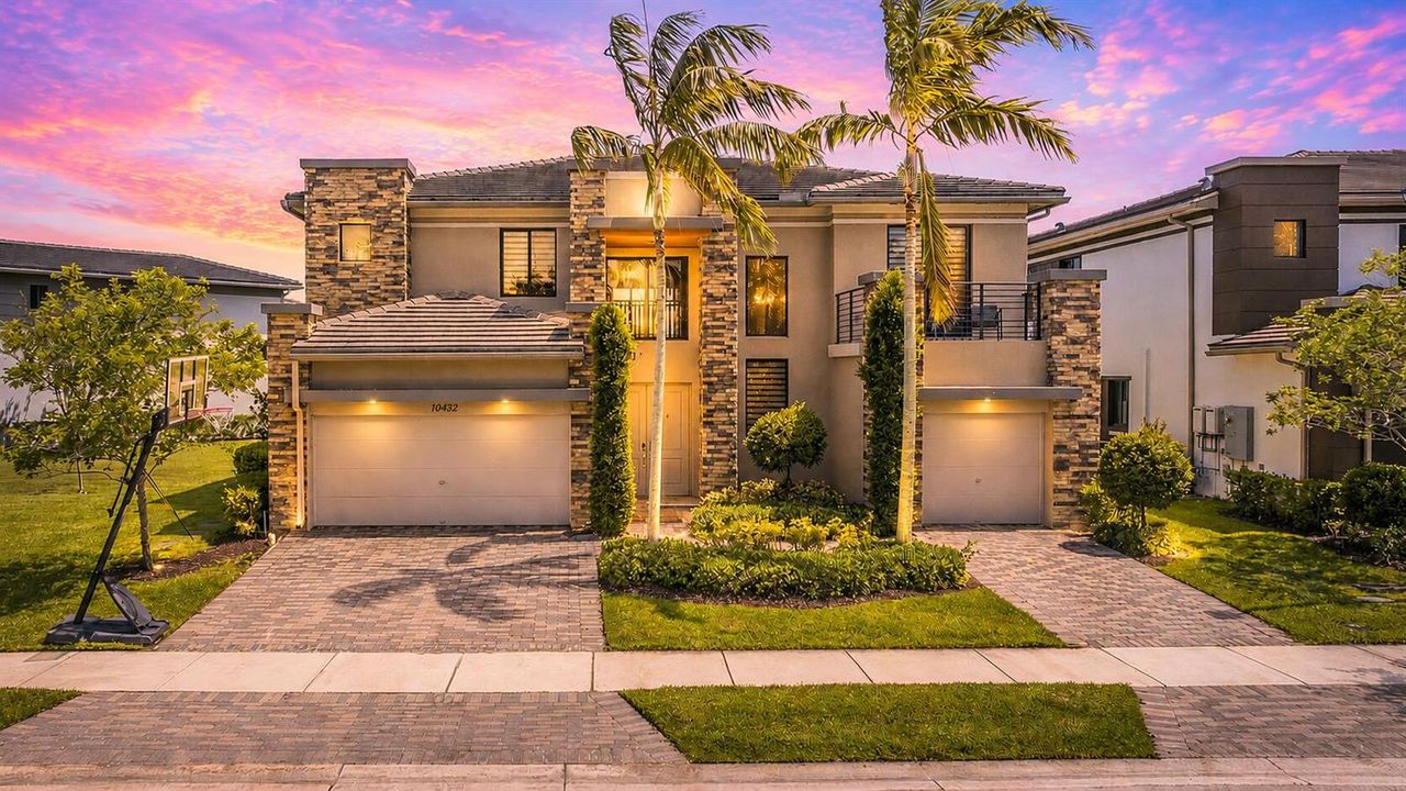 Modern home at sunset with palm trees