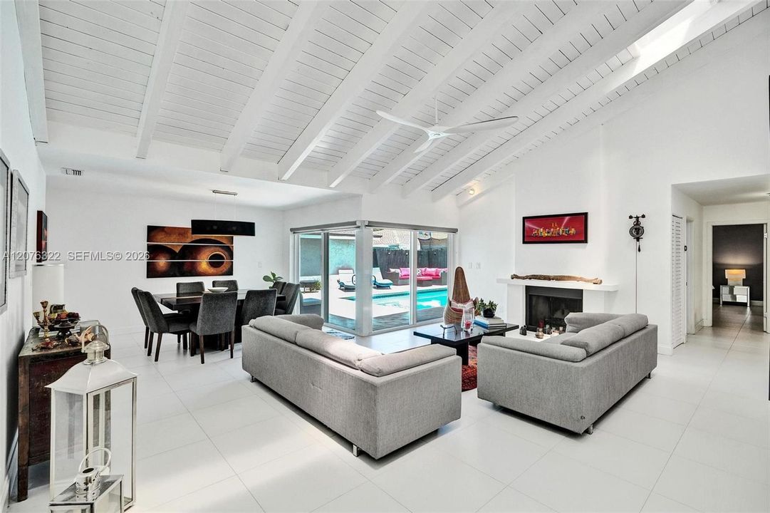 Wow! Vaulted Ceilings, fireplace, gorgeous flooring, view to pool deck, skylights.  IMPACT WINDOWS.