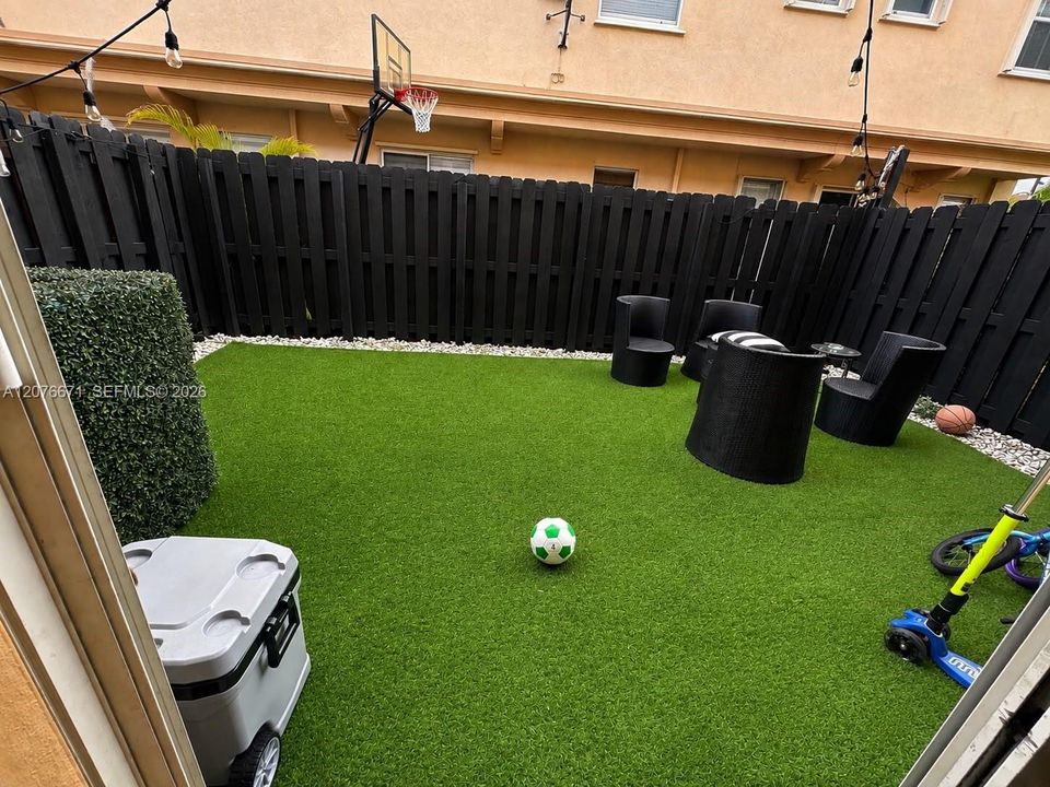 Private back yard with artificial grass and stone perimeter