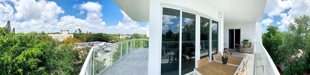 huge 350 SF double wraparound balcony with large lounge setting, 4 sets of doulbe impact glass doors