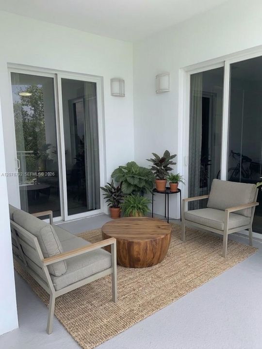 huge 350 SF double wraparound balcony with large lounge setting, 4 sets of doulbe impact glass doors