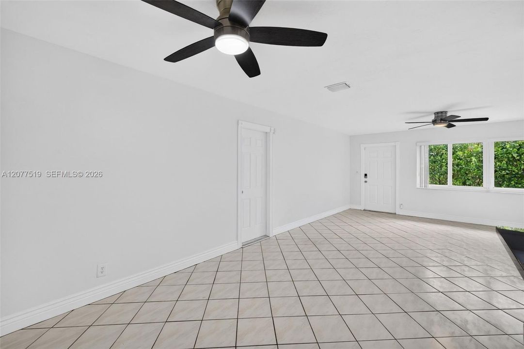 Bright living room featuring tile flooring, neutral finishes and ample natural light.
