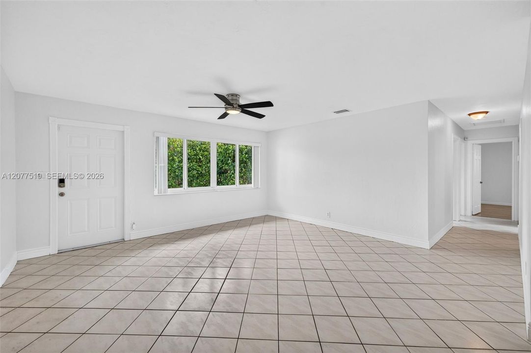 Bright living room featuring tile flooring, neutral finishes and ample natural light.