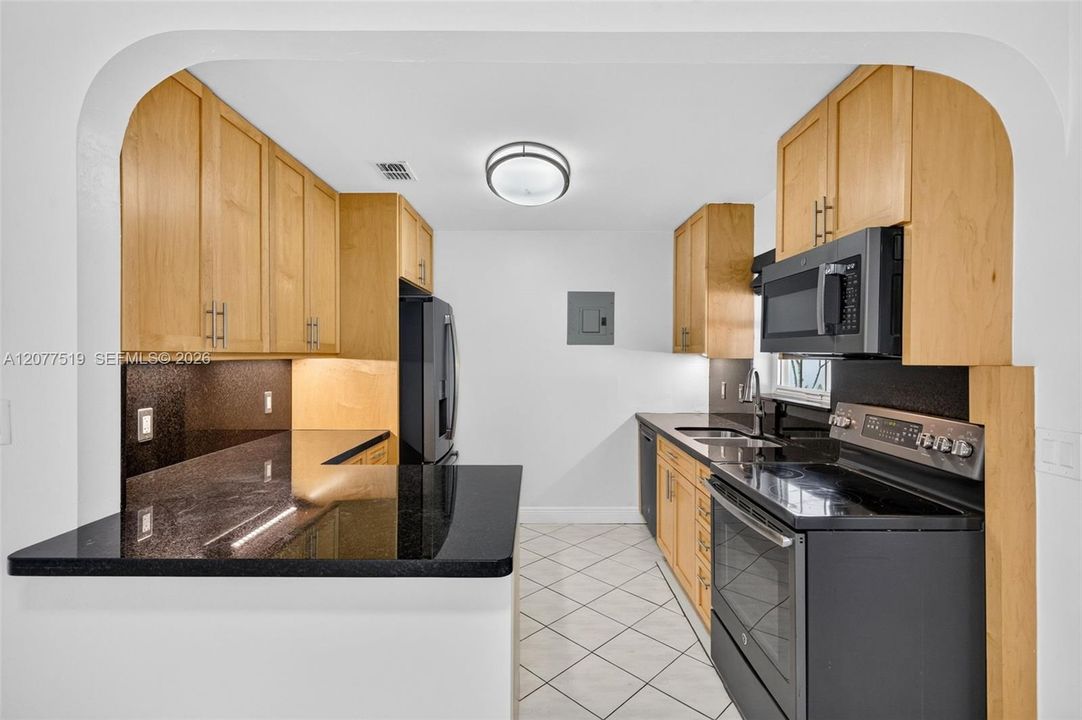 Updated 2017 kitchen featuring birch cabinetry, quartz countertops and GE appliances. Virtually-Staged.