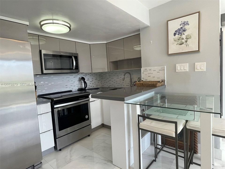Modern kitchen with bar, table and seats