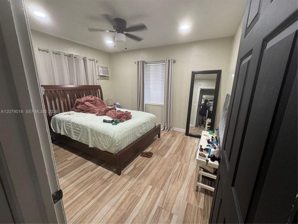 Room interior featuring wood-finish flooring, recessed lighting, and a ceiling fan