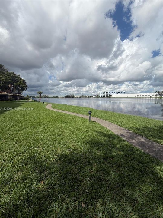 Large lake front with lit walking/jogging trail behind the unit.