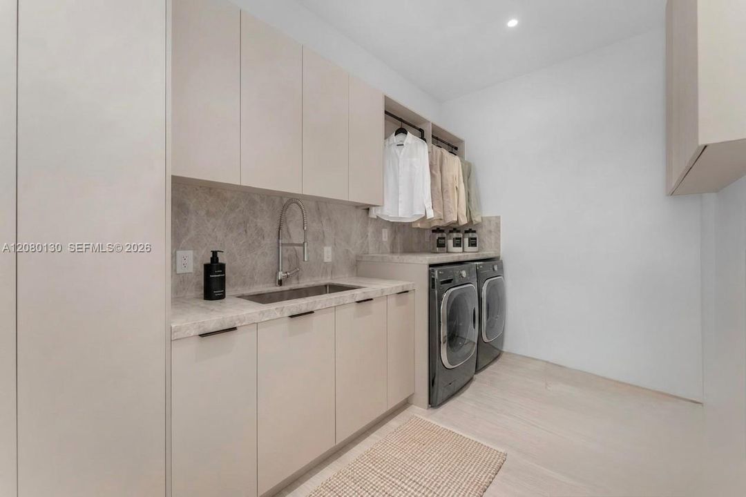 Laudry Room. Disclaimer: Several photographs presented in this listing contain digitally added furniture, artwork, and decor. These virtually staged images are intended solely for illustrative purposes.