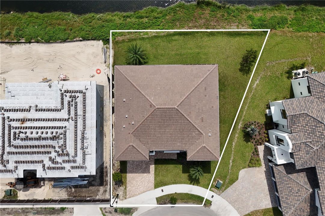 Aerial property overview featuring a tiled roof and a paved driveway