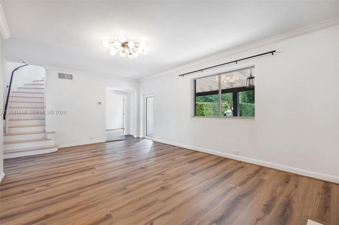Living room leading to the dining/family room, guest bathroom & upstairs