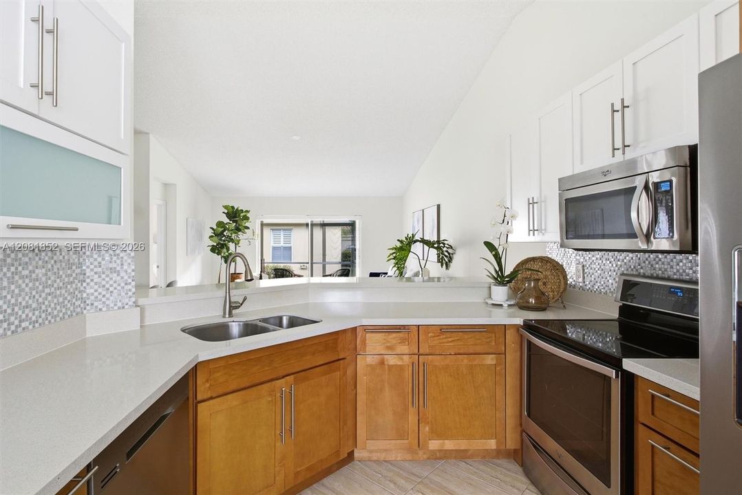 Gourmet kitchen featuring crisp white cabinetry, quartz counters, and stainless appliances.