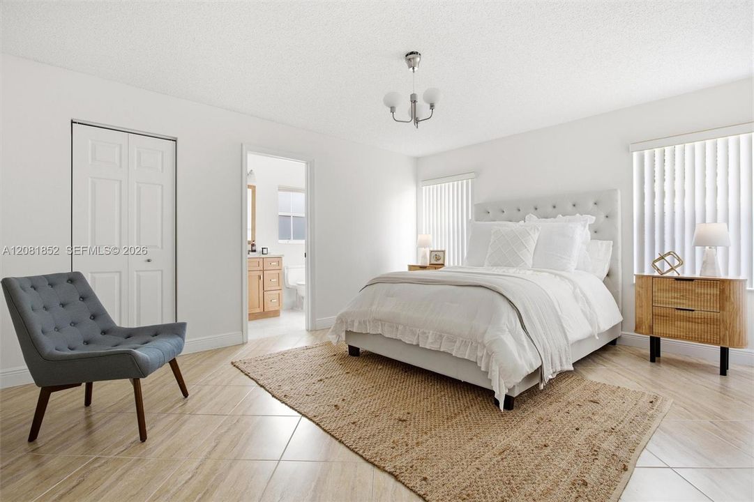 Serene primary suite with warm wood flooring and abundant natural light.