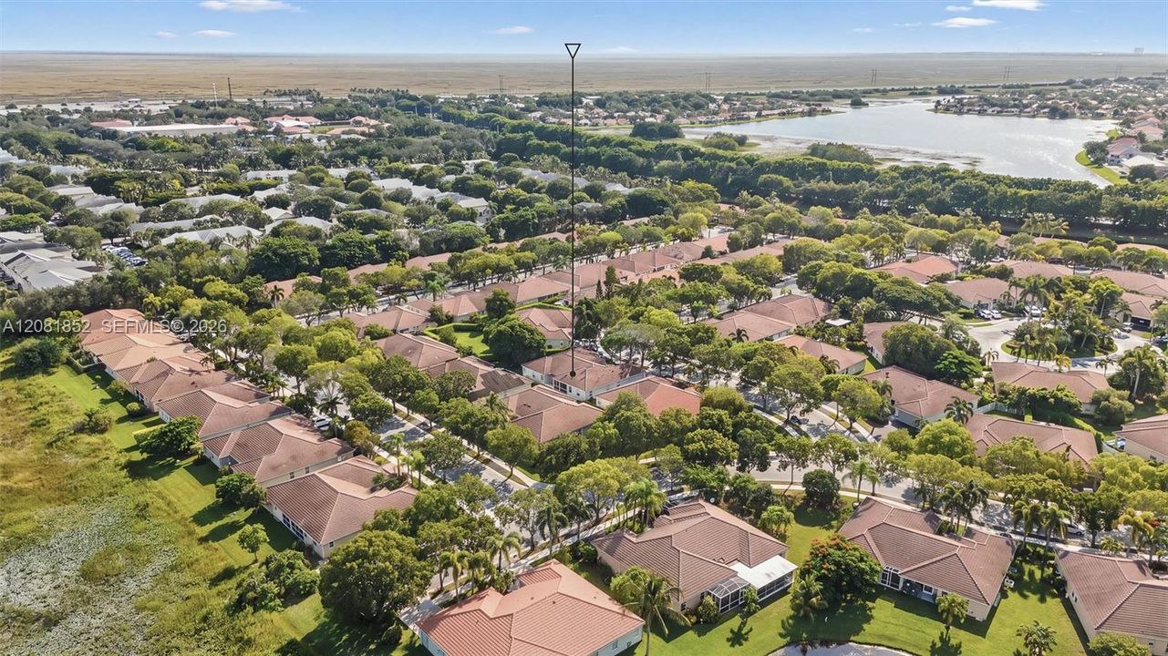 Panoramic aerial perspective of the community's serene lake and rooftops.